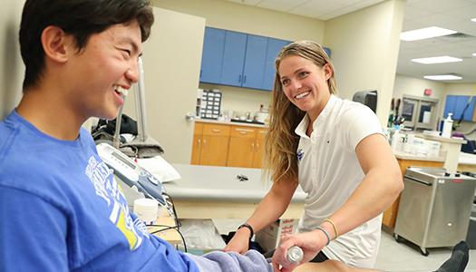 一名运动训练学生在诊所帮助病人康复